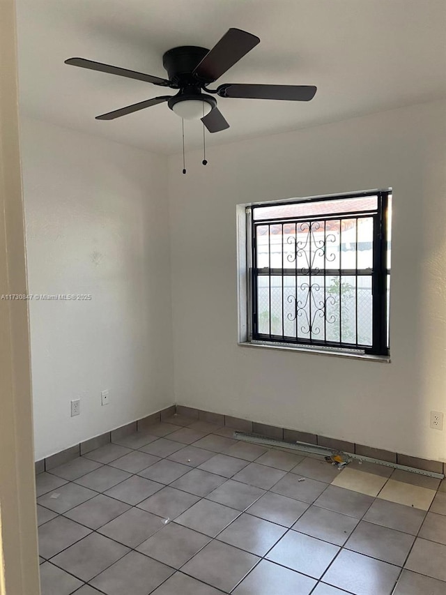 tiled spare room featuring ceiling fan