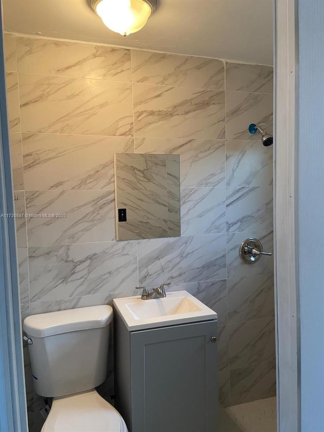 bathroom featuring a shower, toilet, and vanity