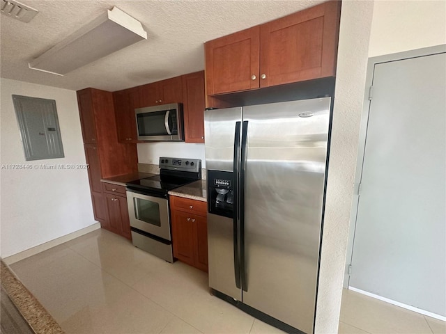 kitchen with a textured ceiling, appliances with stainless steel finishes, and electric panel