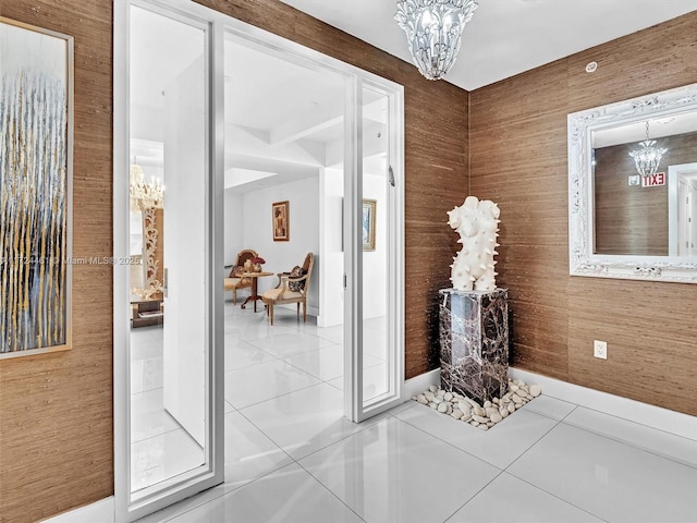 doorway to outside with tile patterned floors and a notable chandelier