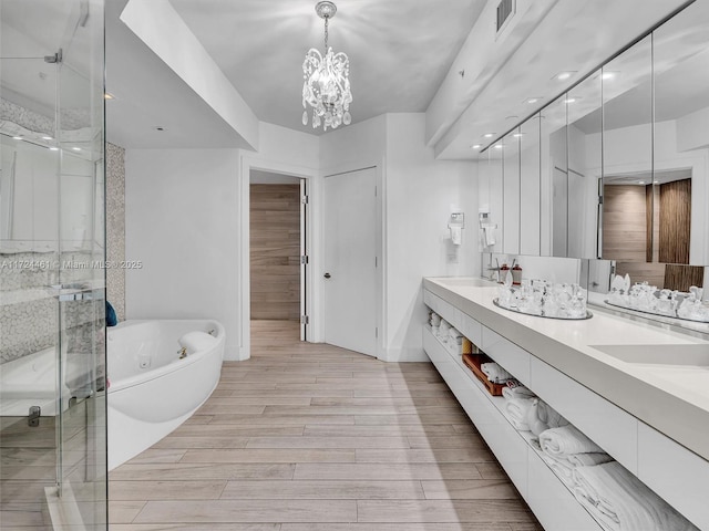 bathroom with vanity, a notable chandelier, and plus walk in shower