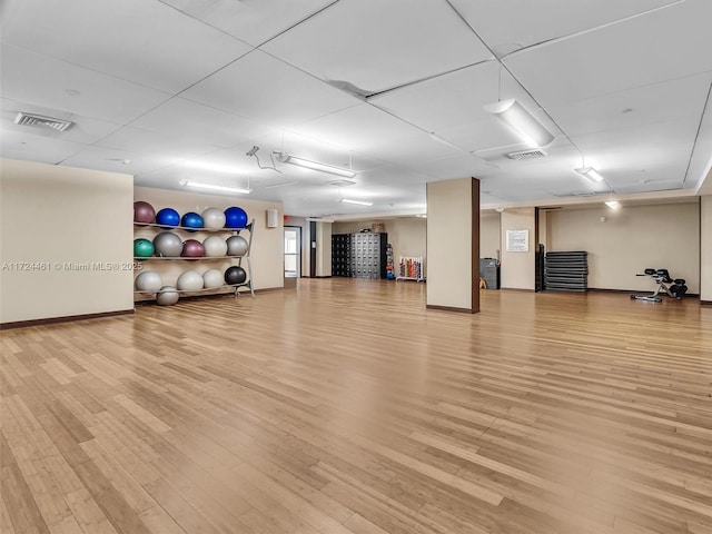 exercise room with light hardwood / wood-style flooring