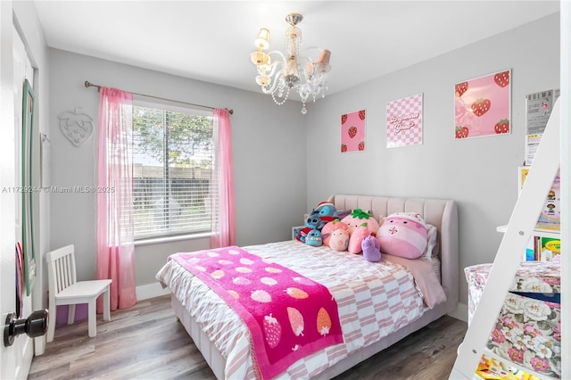 bedroom with wood-type flooring and a notable chandelier