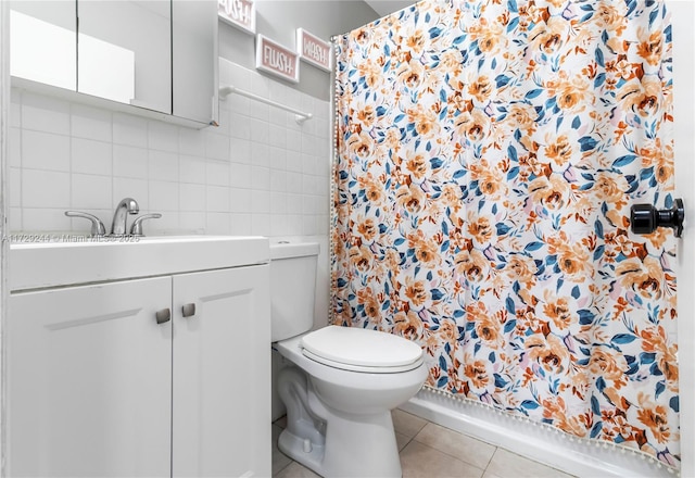 bathroom with toilet, vanity, and tile patterned flooring