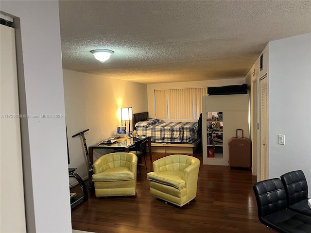 bedroom with a textured ceiling and dark hardwood / wood-style flooring