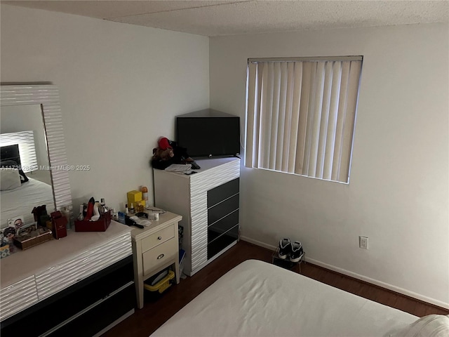 bedroom with a textured ceiling and dark hardwood / wood-style flooring