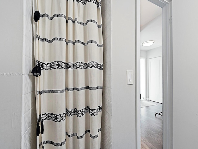 bathroom with curtained shower and wood-type flooring