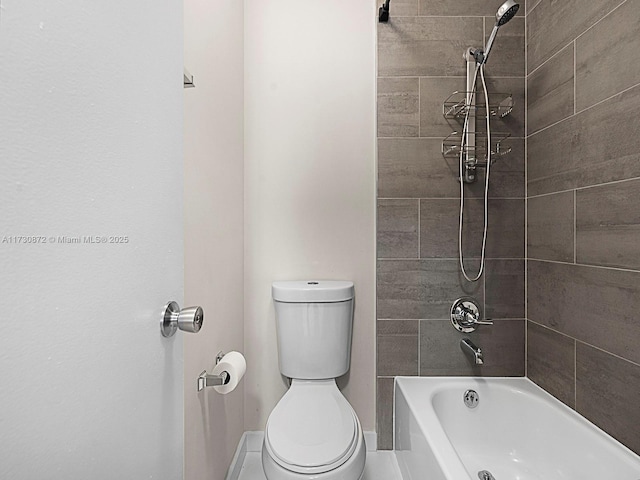 bathroom with toilet and tiled shower / bath