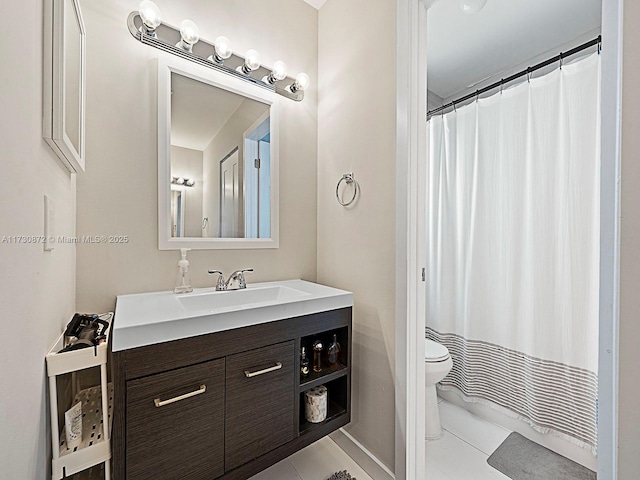 bathroom featuring tile patterned floors, toilet, vanity, and walk in shower