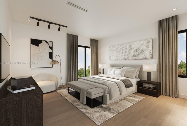 bedroom featuring hardwood / wood-style flooring and track lighting