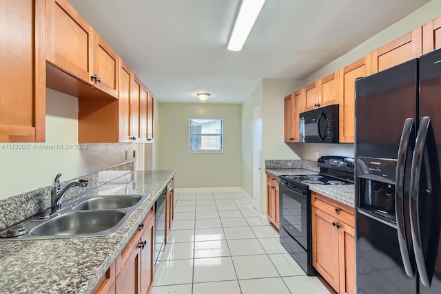 kitchen with sink, stone countertops, light tile patterned floors, and black appliances