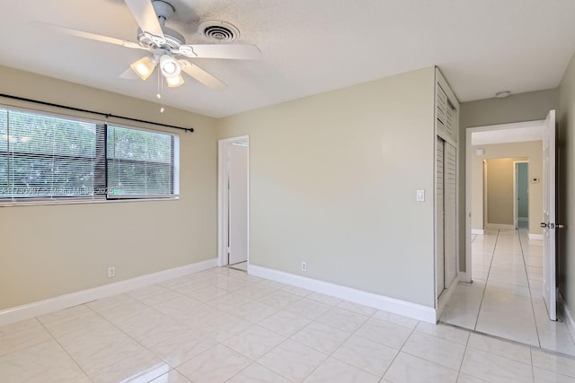 tiled spare room featuring ceiling fan