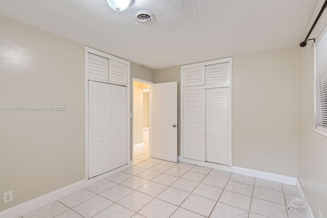 unfurnished bedroom featuring light tile patterned floors and a textured ceiling