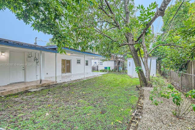 view of yard featuring a patio and a storage shed