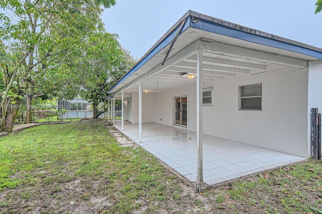 back of house with a lawn and a patio