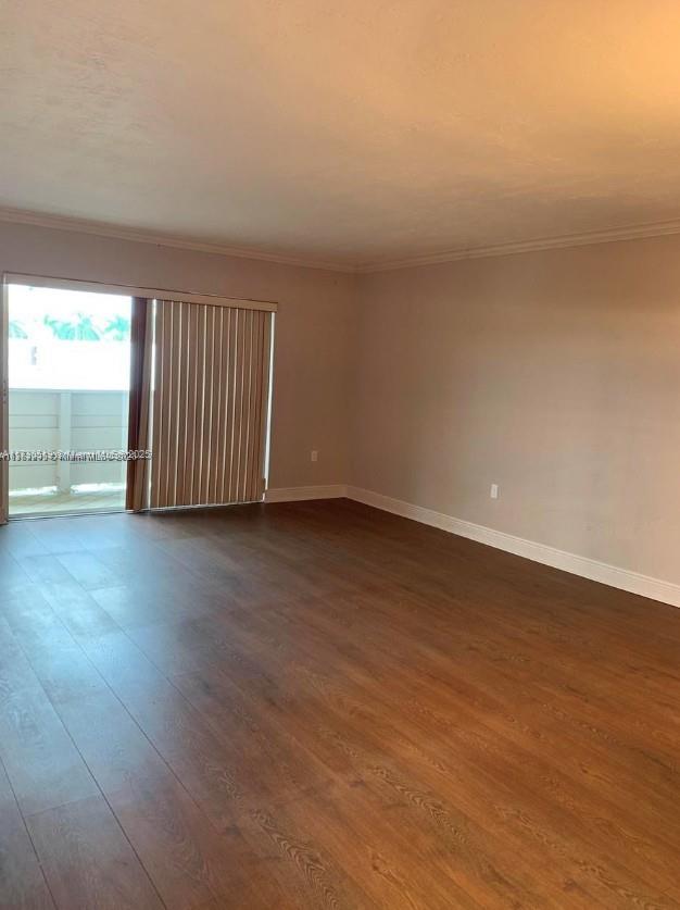 unfurnished room featuring ornamental molding and dark hardwood / wood-style flooring