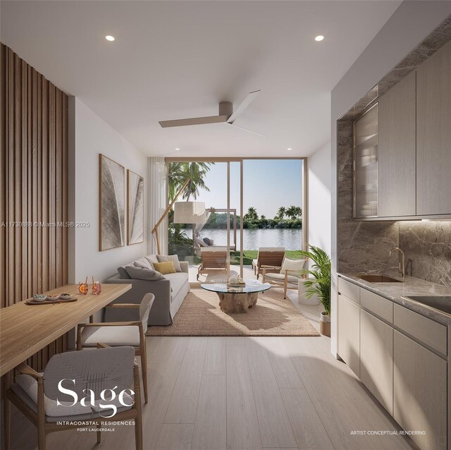 living room featuring ceiling fan, sink, light wood-type flooring, a water view, and a wall of windows