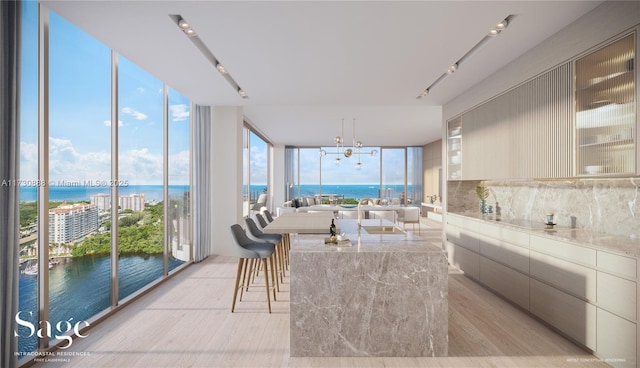 sunroom with a water view and an inviting chandelier