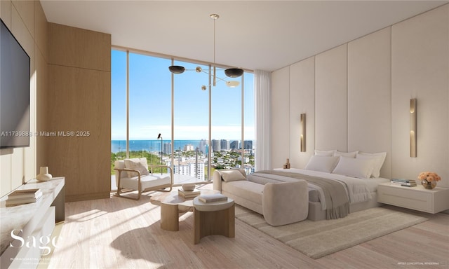 bedroom featuring a wall of windows, a water view, and light wood-type flooring