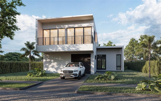 contemporary house with stucco siding, driveway, and a balcony
