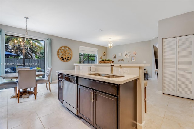 kitchen featuring pendant lighting, dishwasher, sink, a notable chandelier, and dark brown cabinetry