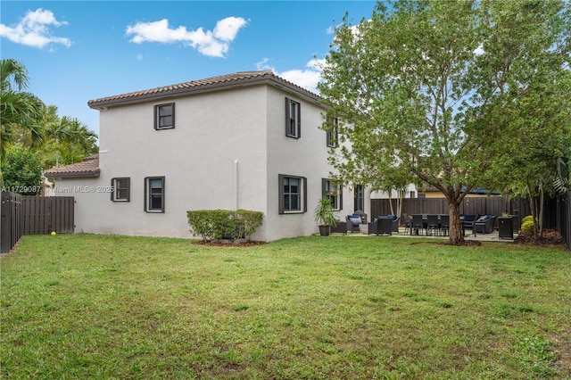 back of property featuring an outdoor living space, a patio area, and a lawn