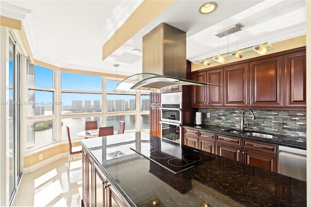 kitchen featuring sink, appliances with stainless steel finishes, dark stone countertops, island exhaust hood, and decorative light fixtures