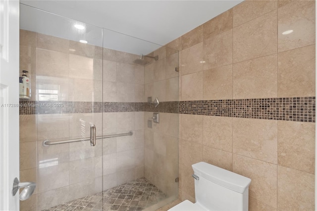 bathroom with toilet and a shower with shower door