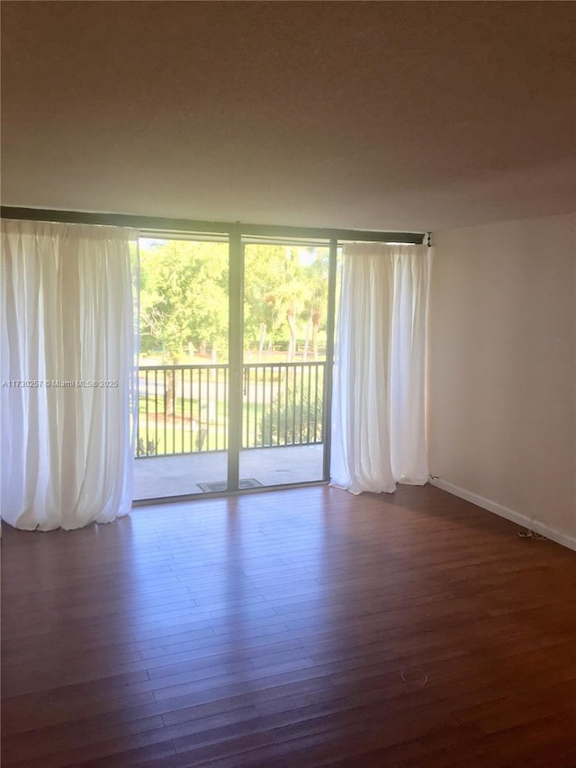 unfurnished room with dark hardwood / wood-style flooring