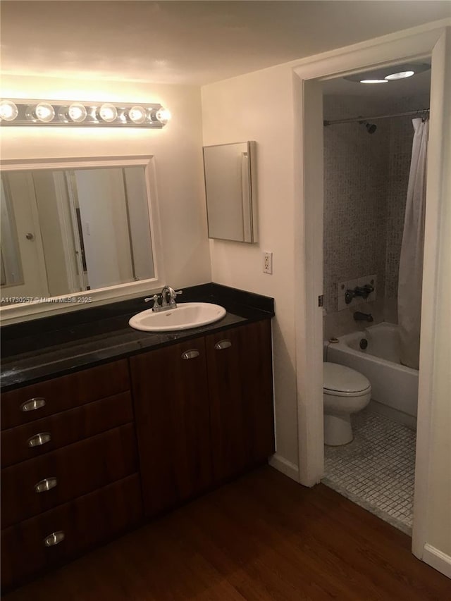 full bathroom with vanity, toilet, hardwood / wood-style floors, and shower / tub combo with curtain