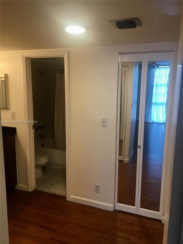 unfurnished bedroom featuring dark hardwood / wood-style floors and ensuite bath