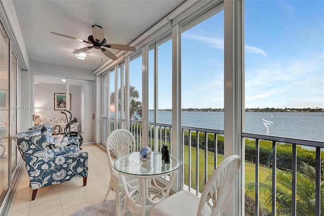 sunroom with a water view and ceiling fan