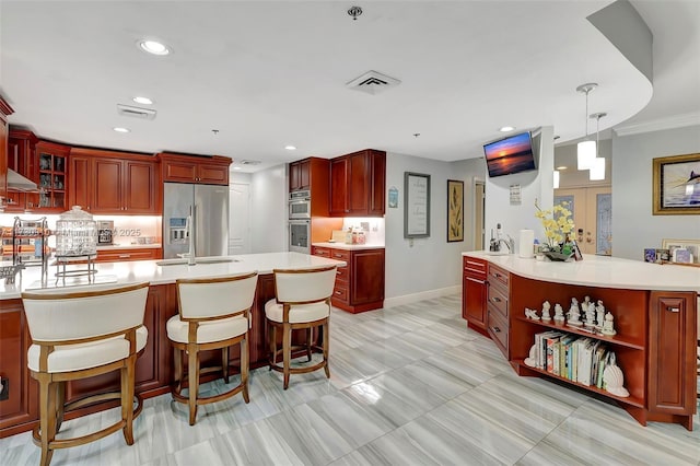 kitchen with crown molding, a kitchen breakfast bar, kitchen peninsula, pendant lighting, and stainless steel appliances