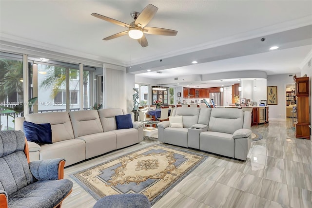 living room featuring ceiling fan, ornamental molding, and a healthy amount of sunlight