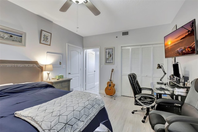 bedroom with light wood-type flooring, ceiling fan, and a closet