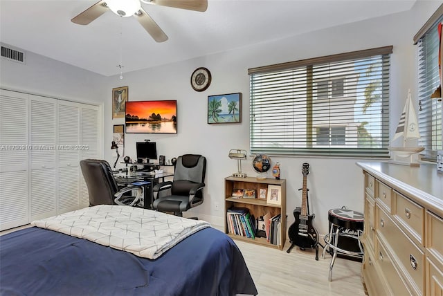 bedroom with light hardwood / wood-style flooring, a closet, and ceiling fan