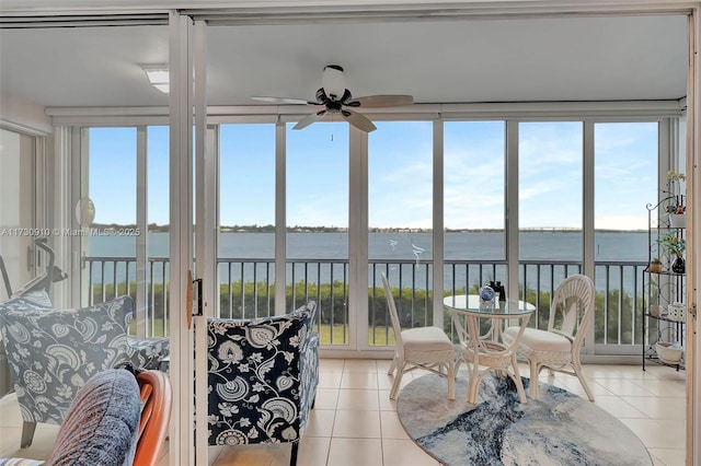 sunroom with a water view and ceiling fan