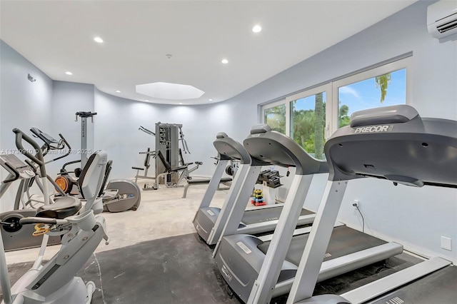 exercise room featuring a wall mounted air conditioner and a skylight