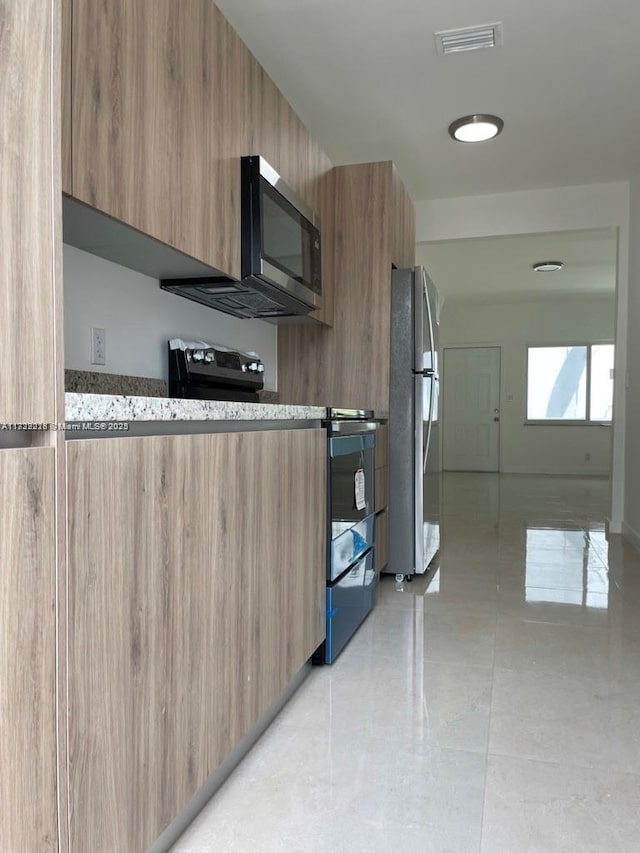 kitchen with light tile patterned floors and appliances with stainless steel finishes