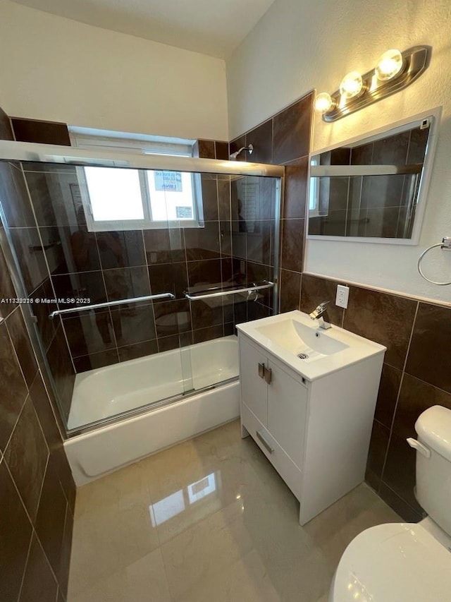 full bathroom with enclosed tub / shower combo, tile walls, toilet, and vanity