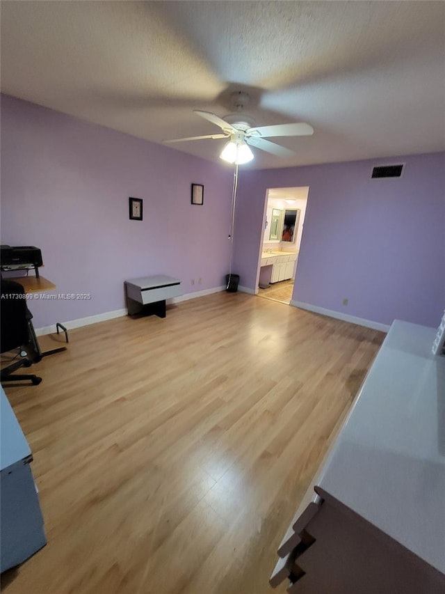 interior space featuring ceiling fan, a textured ceiling, and light hardwood / wood-style flooring