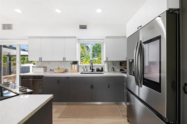 kitchen featuring sink, tasteful backsplash, gray cabinetry, and appliances with stainless steel finishes