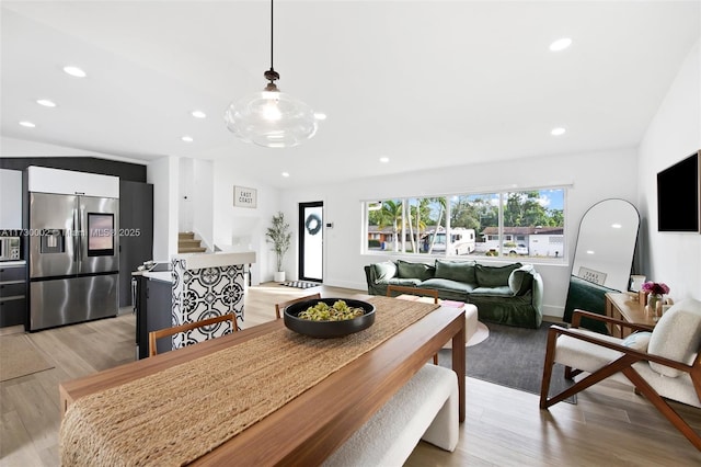 dining area featuring light hardwood / wood-style flooring and lofted ceiling