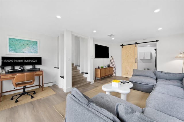 living room featuring hardwood / wood-style flooring, a baseboard heating unit, and a barn door