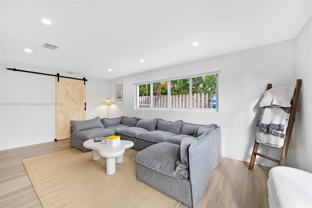 living room with light hardwood / wood-style flooring and a barn door