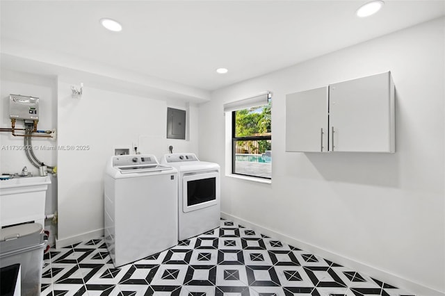 washroom featuring electric panel, water heater, and washer and clothes dryer