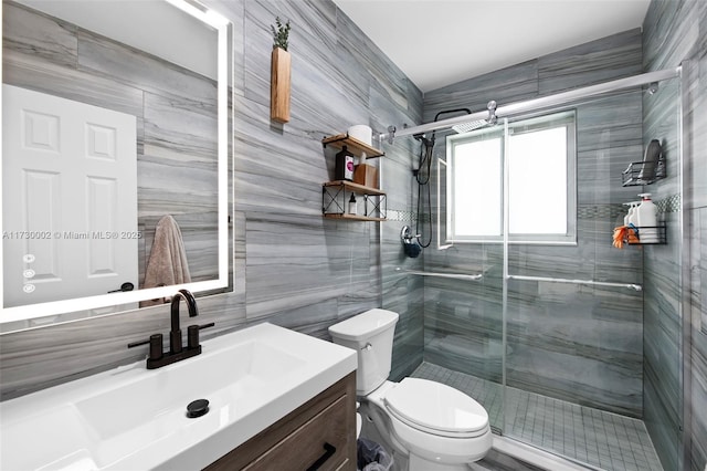 bathroom with tile walls, toilet, vanity, and walk in shower