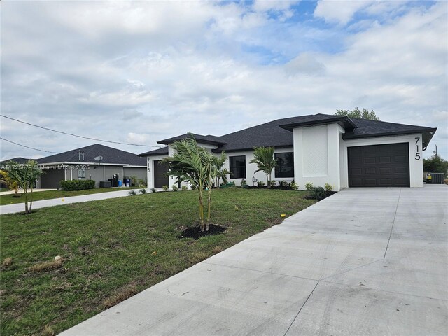 prairie-style home with a garage, concrete driveway, a front lawn, and stucco siding