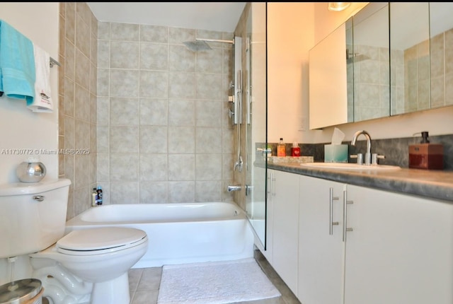 full bathroom featuring vanity, tile patterned flooring, toilet, and tiled shower / bath