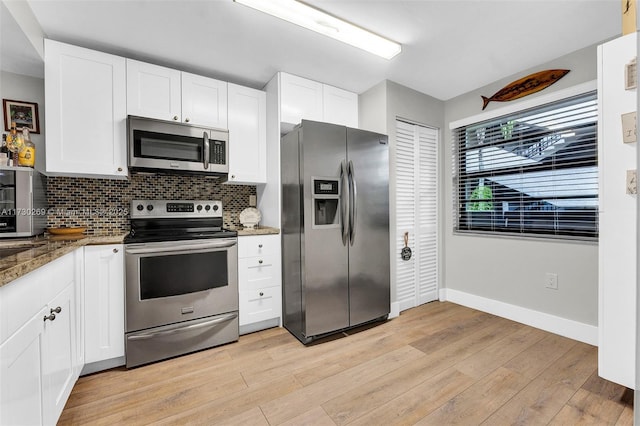 kitchen with light wood-type flooring, stone countertops, tasteful backsplash, stainless steel appliances, and white cabinets